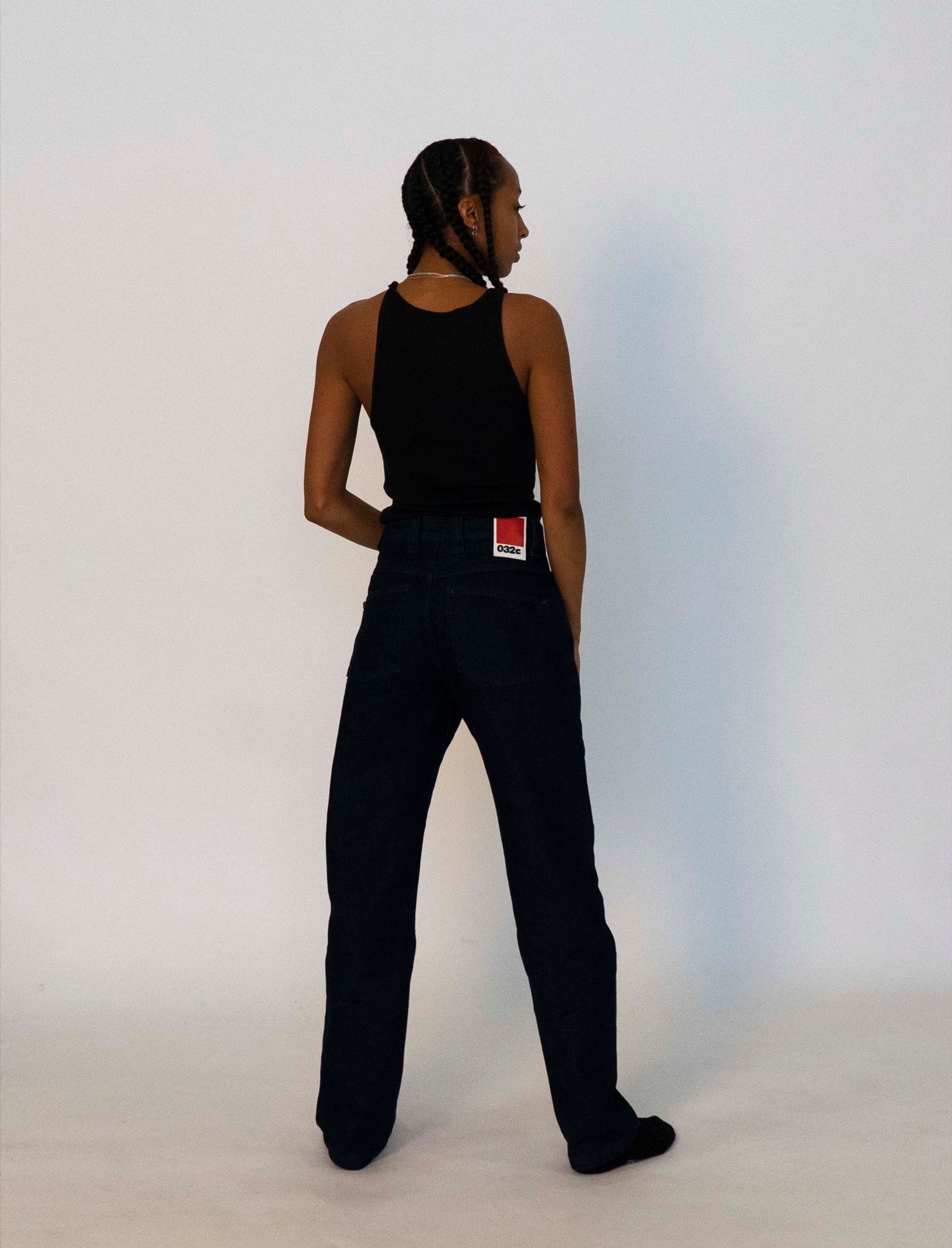 Libell wears the 032c LoveSexDreams ribbed tank in black, and the "next" jeans in dark blue