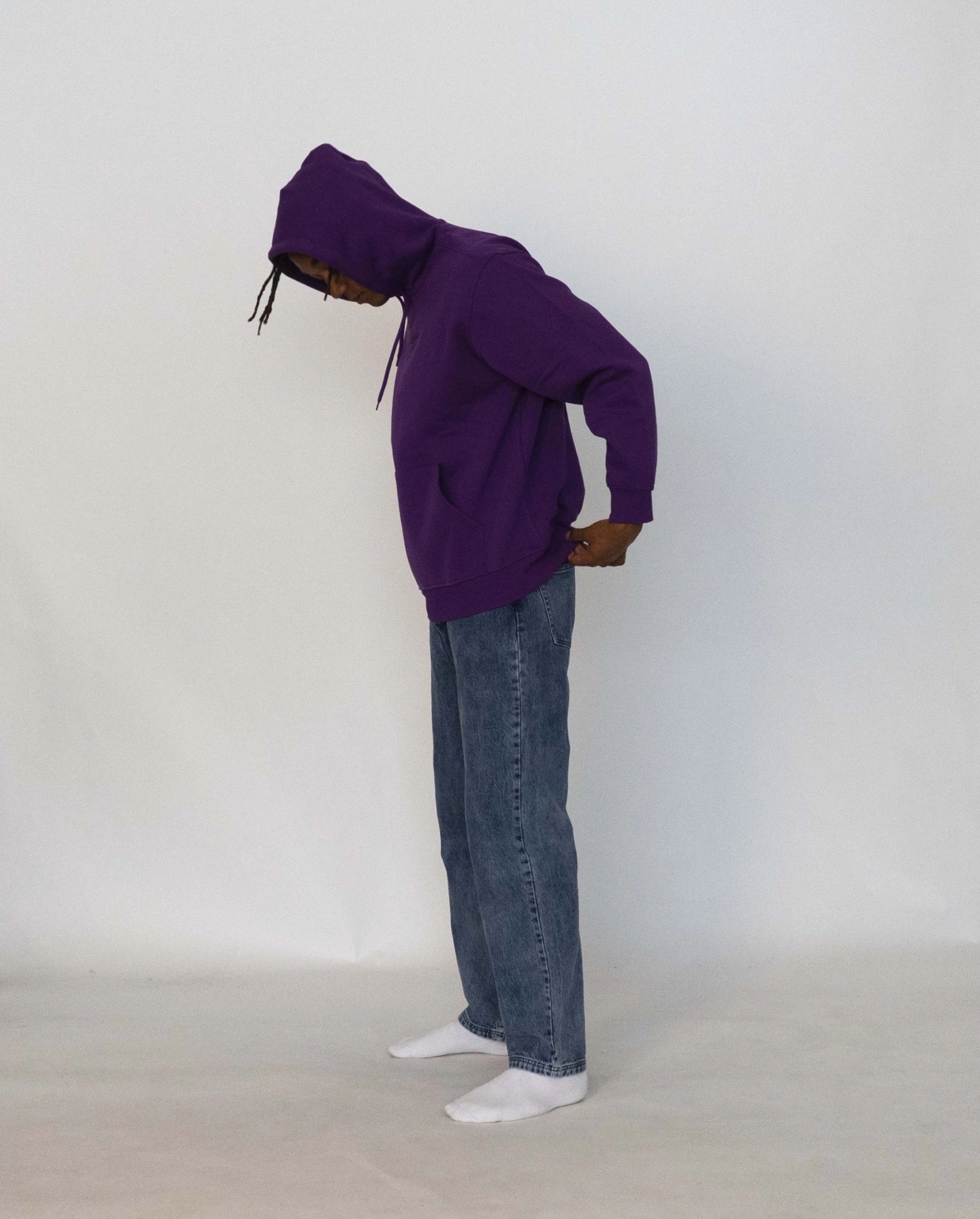 Buyegi wears the 032c LoveSexDreams "Team Société" hoodie in purple and "Next" jeans in light blue