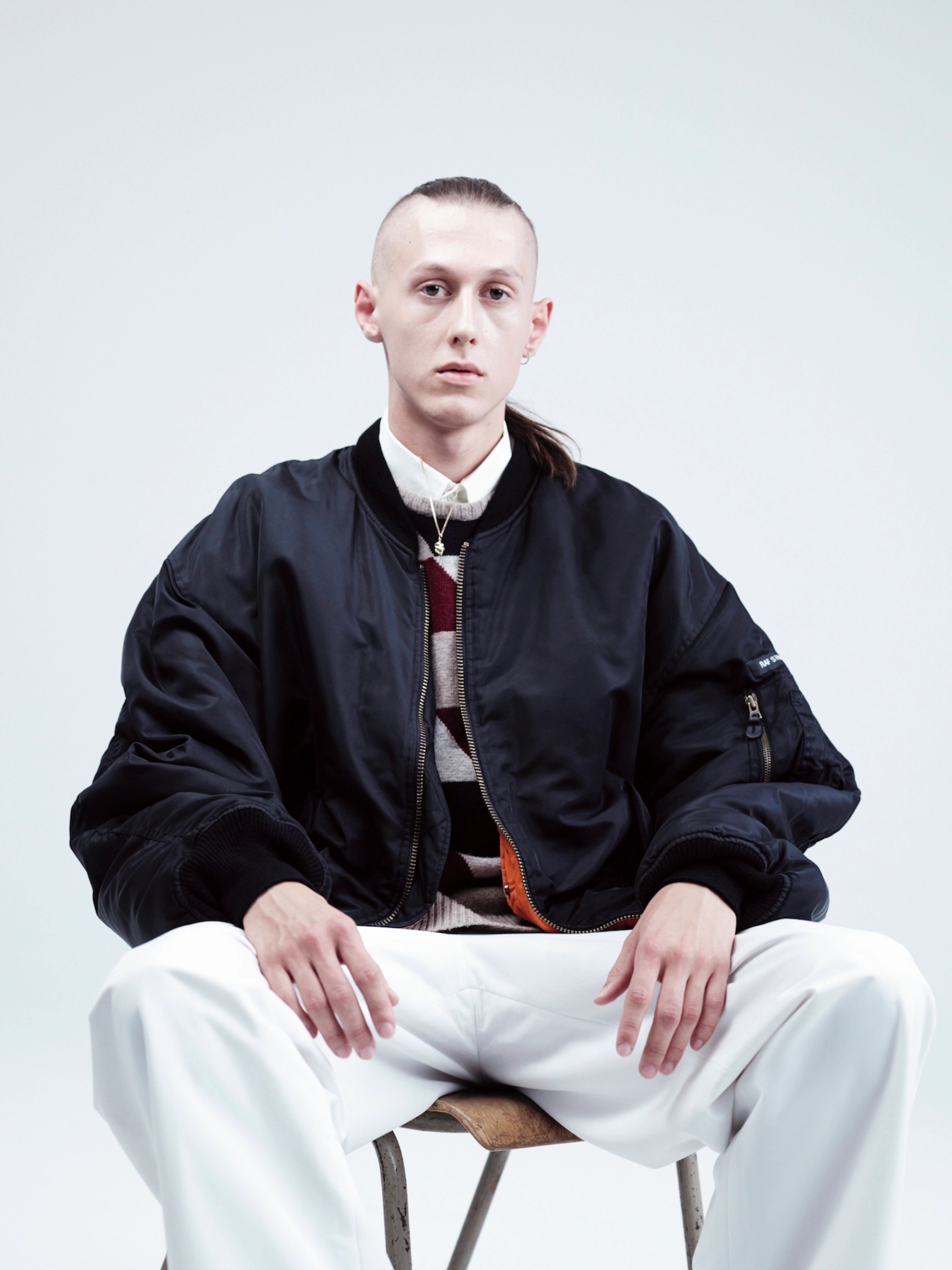 LUKAS: nylon bomber jacket, wool jacquard sweater, cotton shirt, polyester track pants: RAF SIMONS S/S 2000; gold necklace with gold skull pendant and silver earring: RAF SIMONS A/W 2003/2004