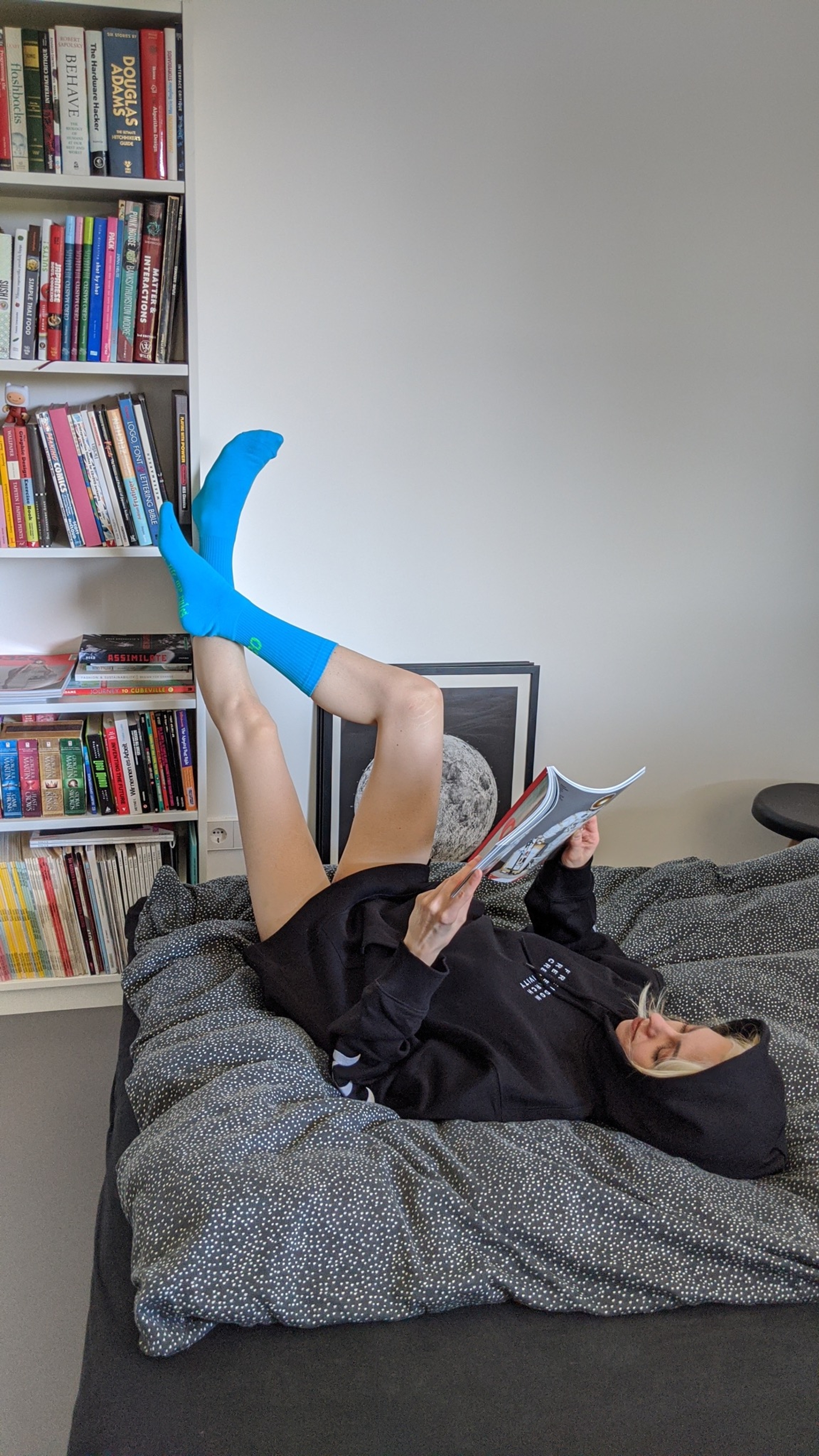 Greta wears 032c LoveSexDreams "My Life My Rules" socks in blue and "Team Sociéte"/"IDEAL" hoodie in black.