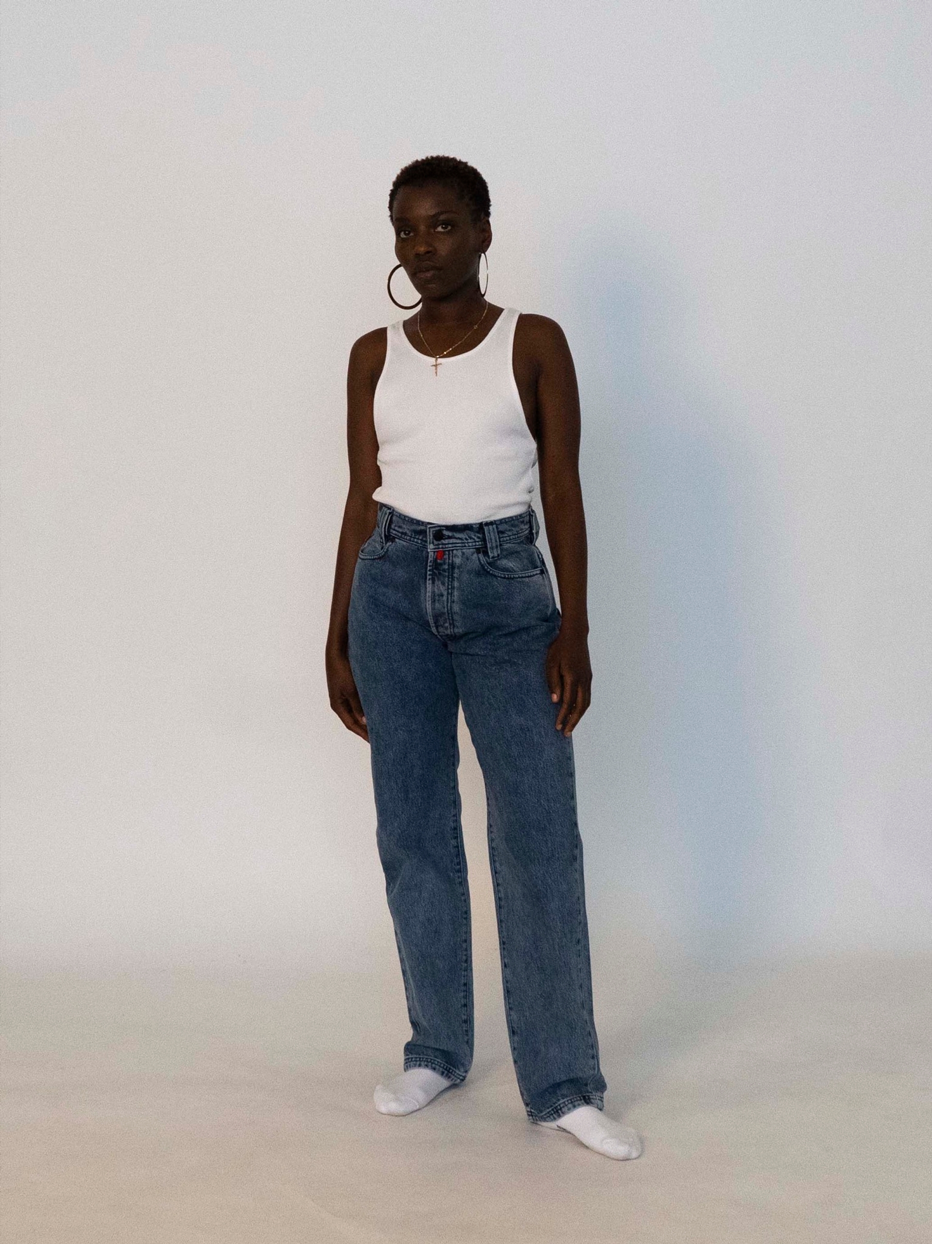 Mariama wears the 032c LoveSexDreams ribbed tank in white and the "Next" jeans in light blue