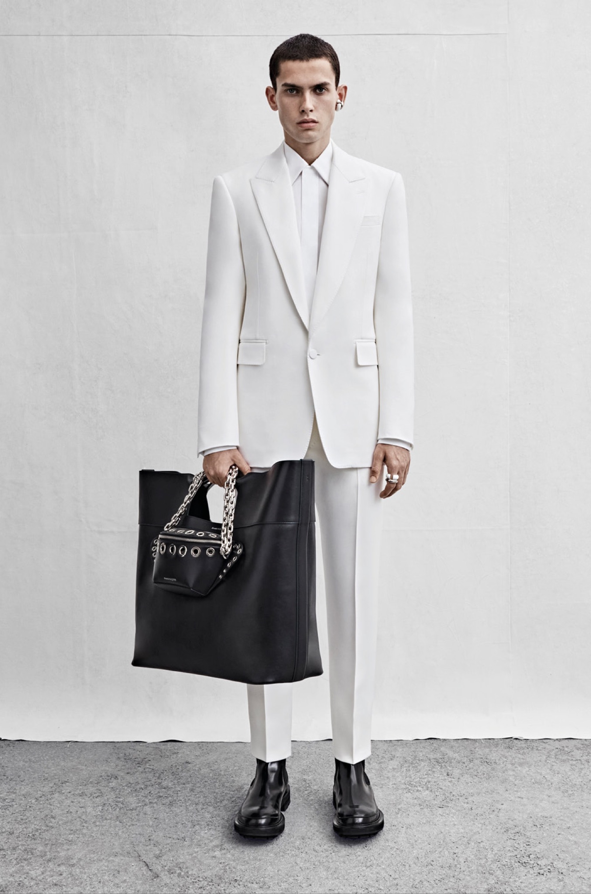 A single-breasted tailored jacket in ivory grain de poudre, a shirt in white cotton poplin and cigarette trousers in ivory grain de poudre.