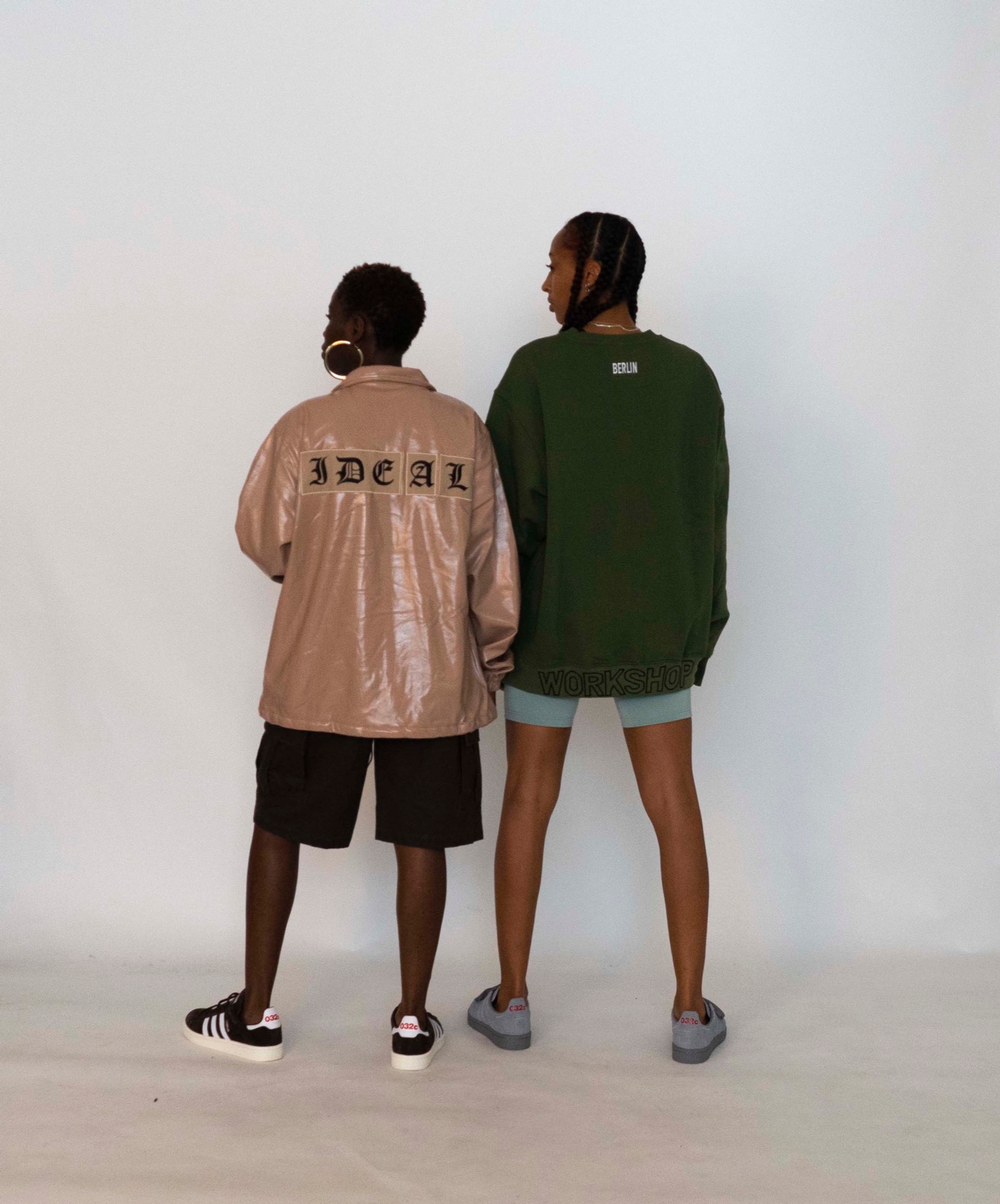 Mariama pairs the 032c LoveSexDreams "IDEAL" Coach Jacket in Beige with Cargo Shorts. Libell wears the "032c Workshop" crewneck in olive and neoprene shorts in mint
