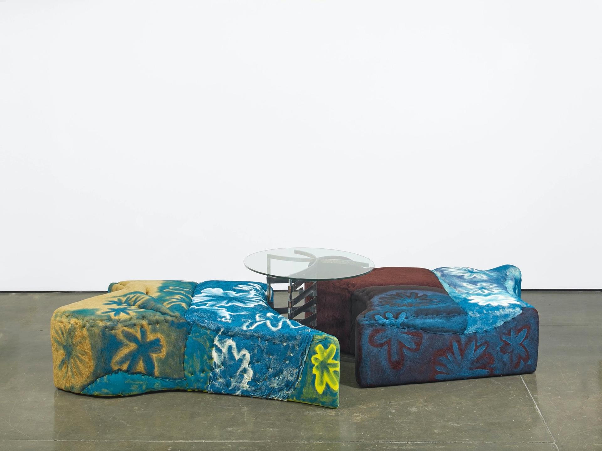Jessi Reaves, Floral ottoman with trapped table, 2017-2019. Plywood, foam, fabric, paint, hardware, glass and steel 30.3 × 145.7 × 102.4 in. (76.96 × 370.08 × 260.10 cm) Courtesy the artist, Herald St, London and Bridget Donahue NYC. Photo: Andy Keate.