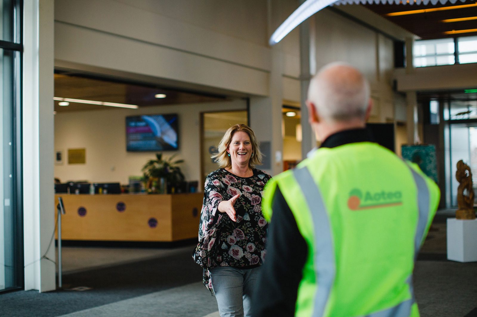 Aotea team member greeting a community partner inside a public building