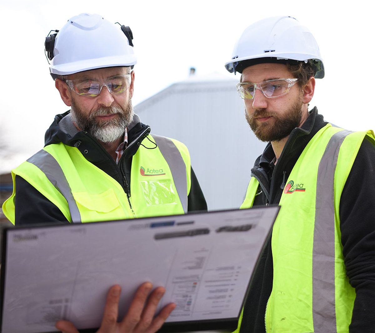 Aotea tradespeople reviewing project plans on a construction site