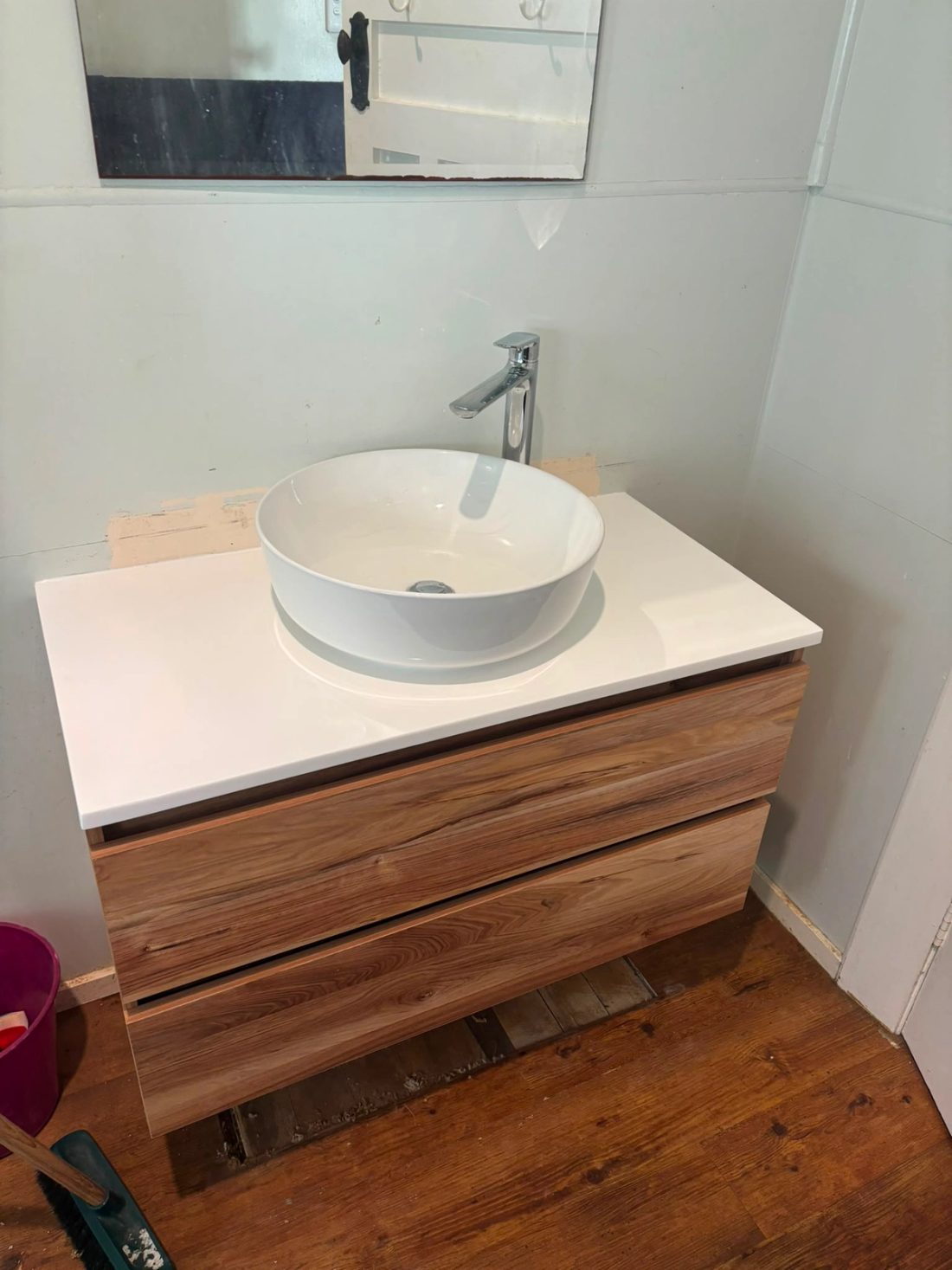 Wall-mounted timber bathroom vanity with a round vessel basin and chrome tap
