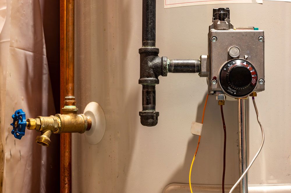 Hot water cylinder with a temperature control unit and connected copper pipes