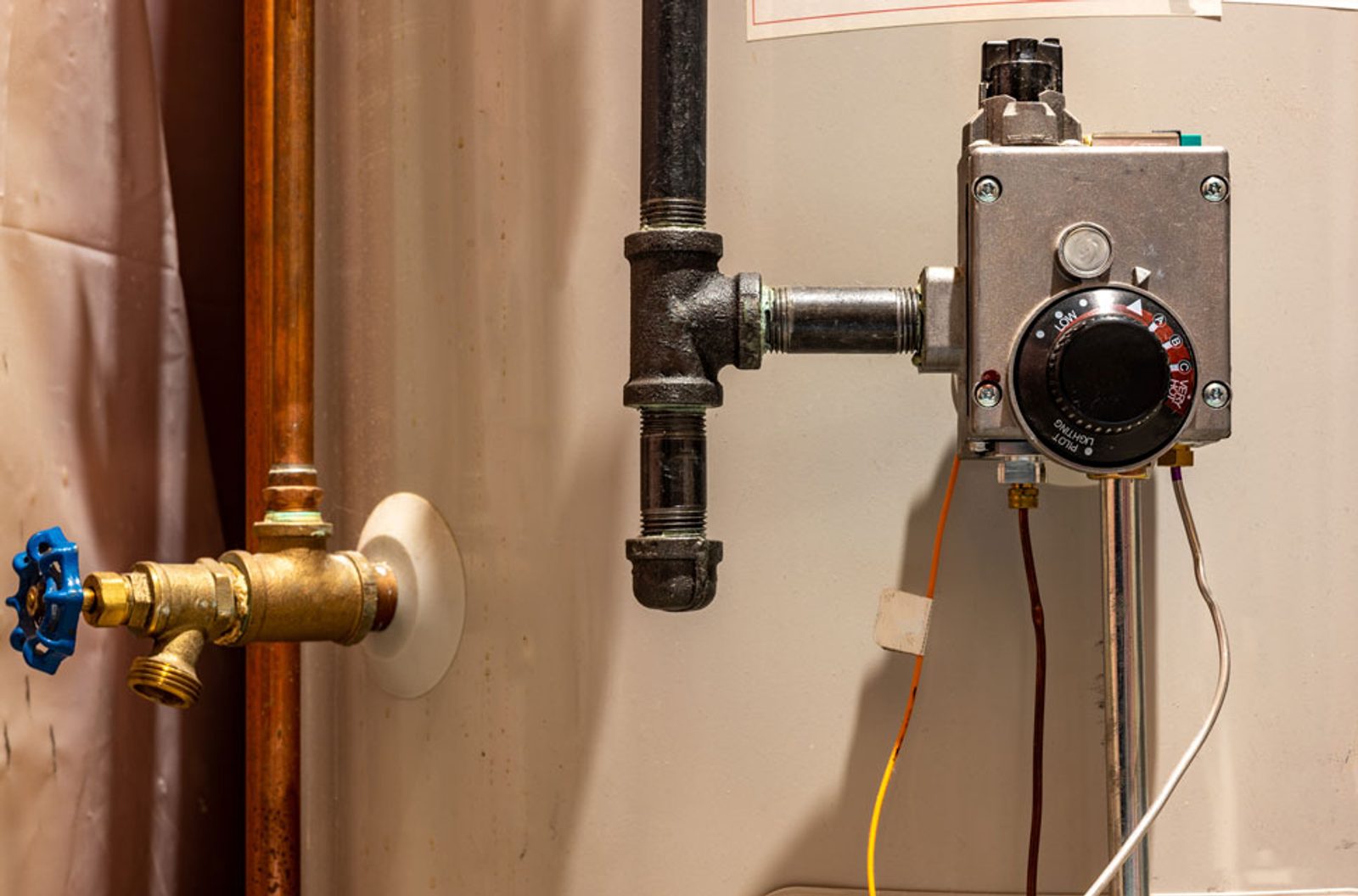 Hot water cylinder with a temperature control unit and connected copper pipes