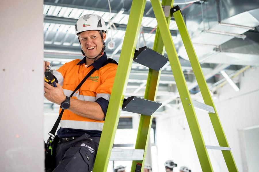 Aotea technician working from a ladder during a commercial installation