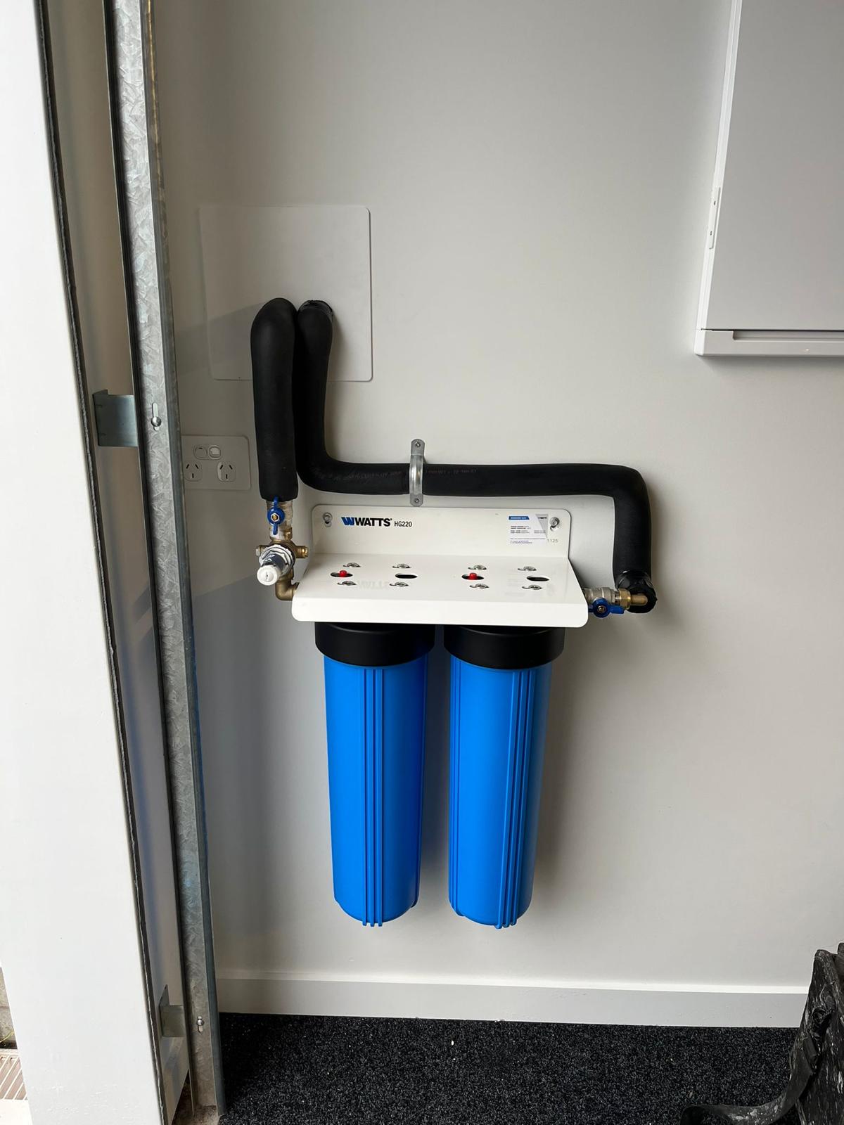 Wall-mounted dual water filtration system with insulated pipework