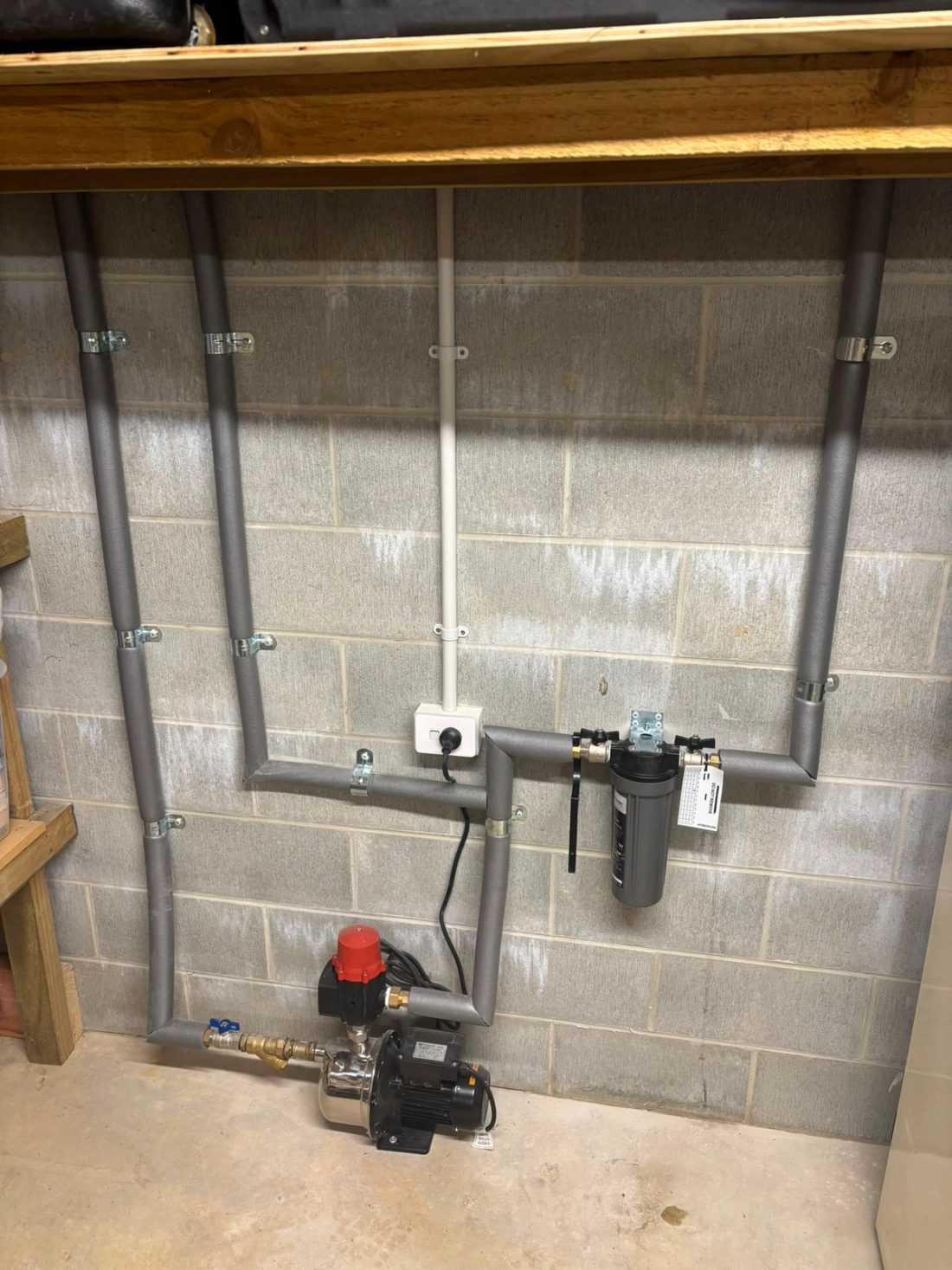 Whole-house water filtration system with pump and wall-mounted pipework