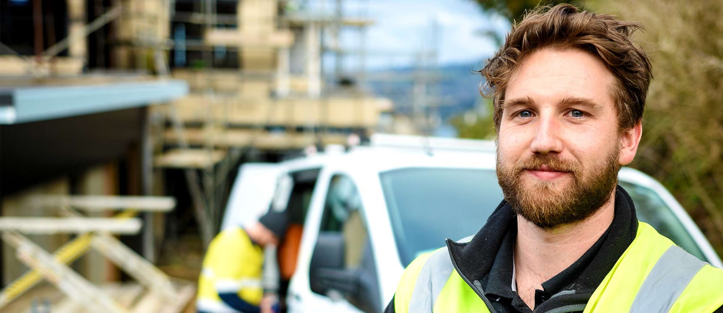 Aotea tradesperson wearing high-visibility workwear at a construction site