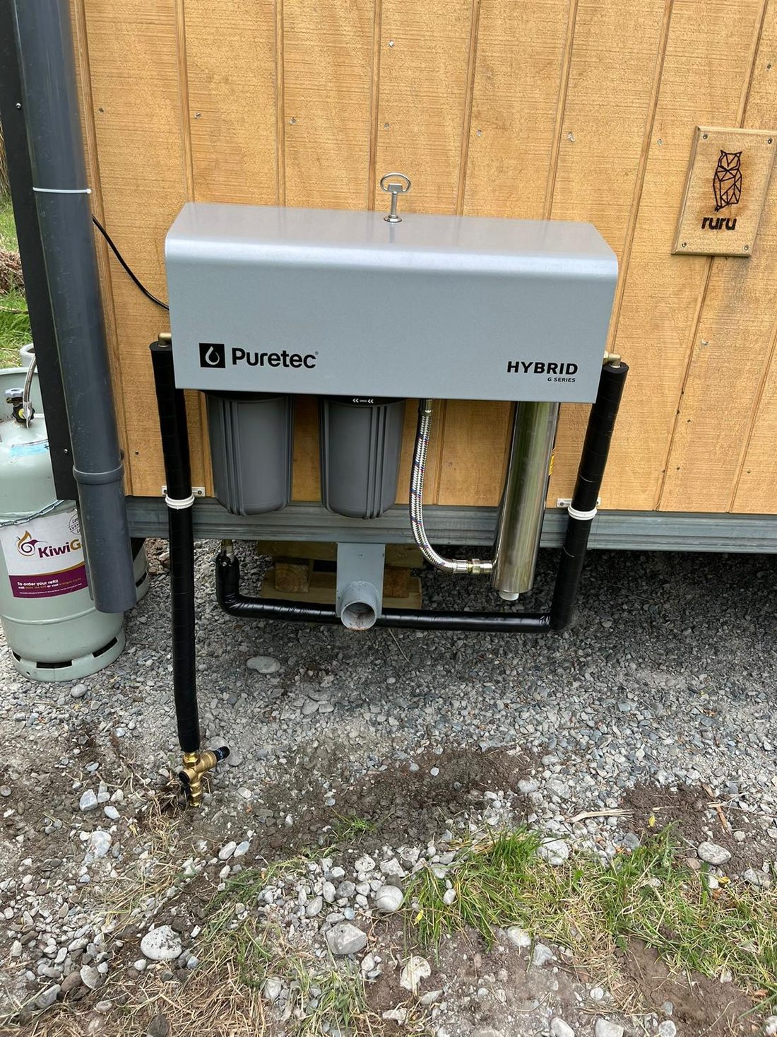 Puretec whole-house water filtration system installed outside a home