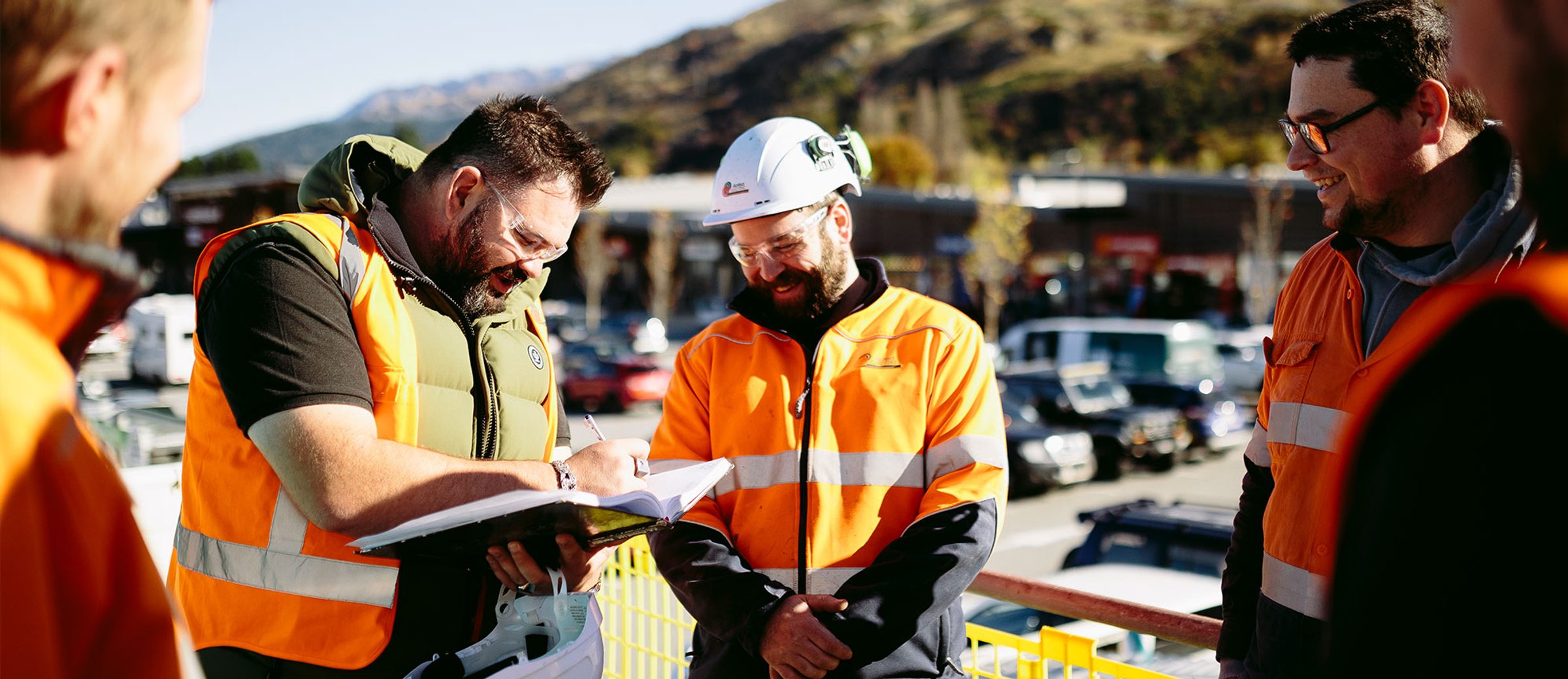 Aotea tradespeople reviewing project plans together at a construction site