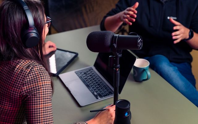 Mic podcast profesional dengan monitor dan aksesori lengkap dalam ruang studio