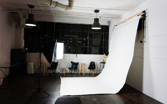 Ruang studio foto produk modern dengan backdrop netral dan pencahayaan profesional terpasang