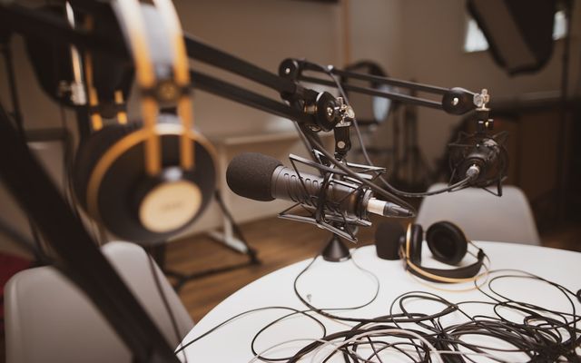 Interior studio podcast modern dengan peralatan rekaman dan sistem pencahayaan profesional