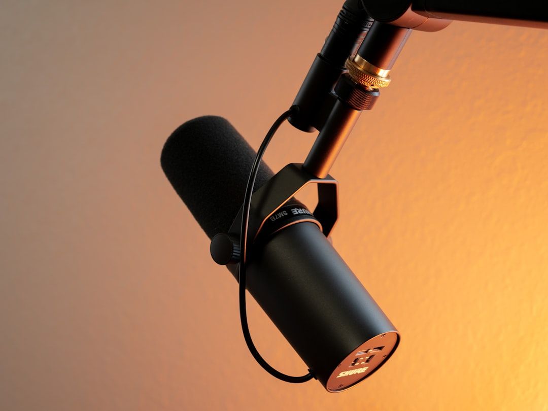 Mikrophone studio rekaman profesional dengan pop filter di booth podcast Sauropodcast