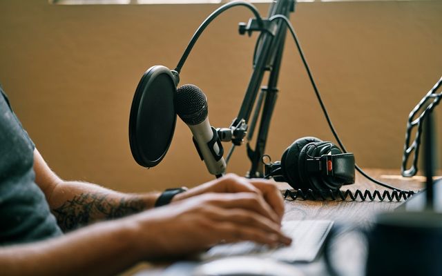 Setup microphone profesional di studio rekaman podcast dengan pop filter dan shock mount
