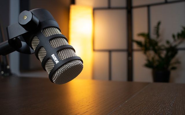 Host mulai podcast dengan mikrofon profesional di ruang studio kedap suara berkualitas