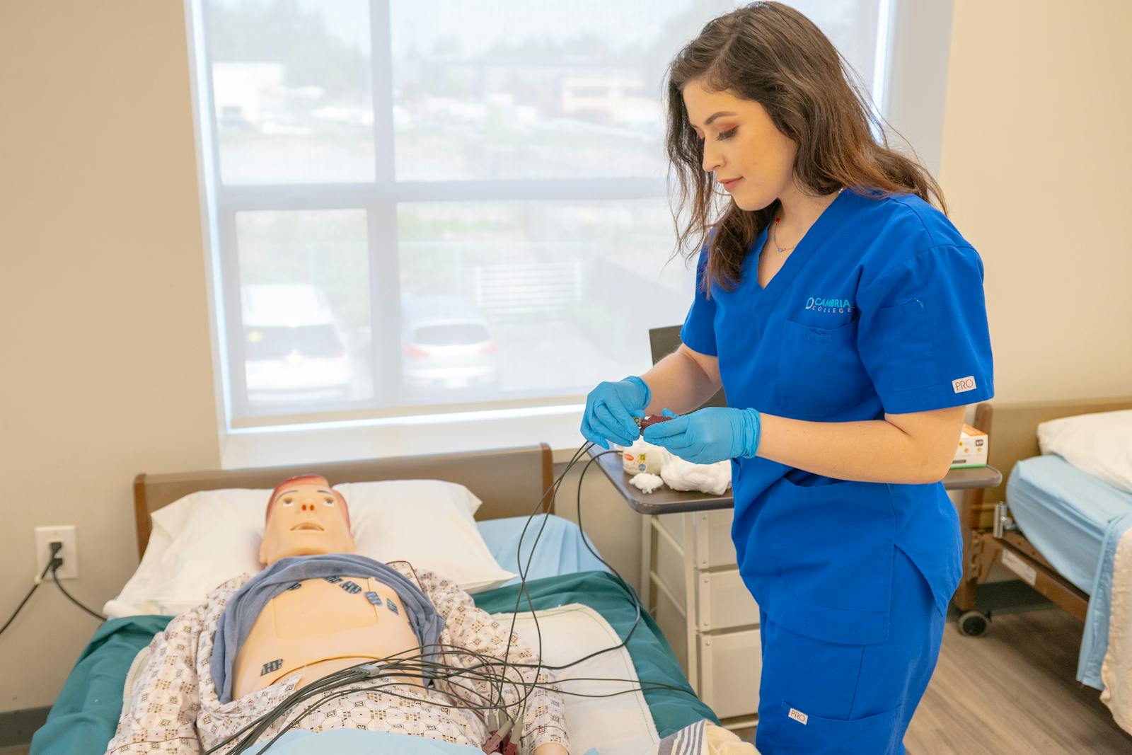 A healthcare student rehearsing a clinical procedure on a training manikin