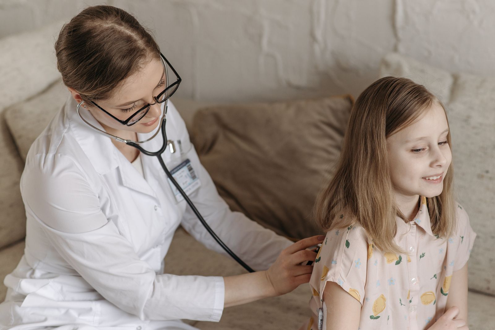 A friendly doctor with a stethoscope examining a smiling child during a check-up