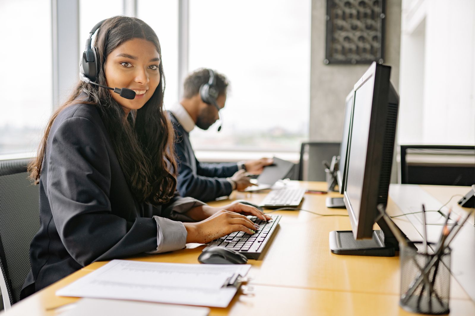 A call centre agent wearing a headset at a workstation