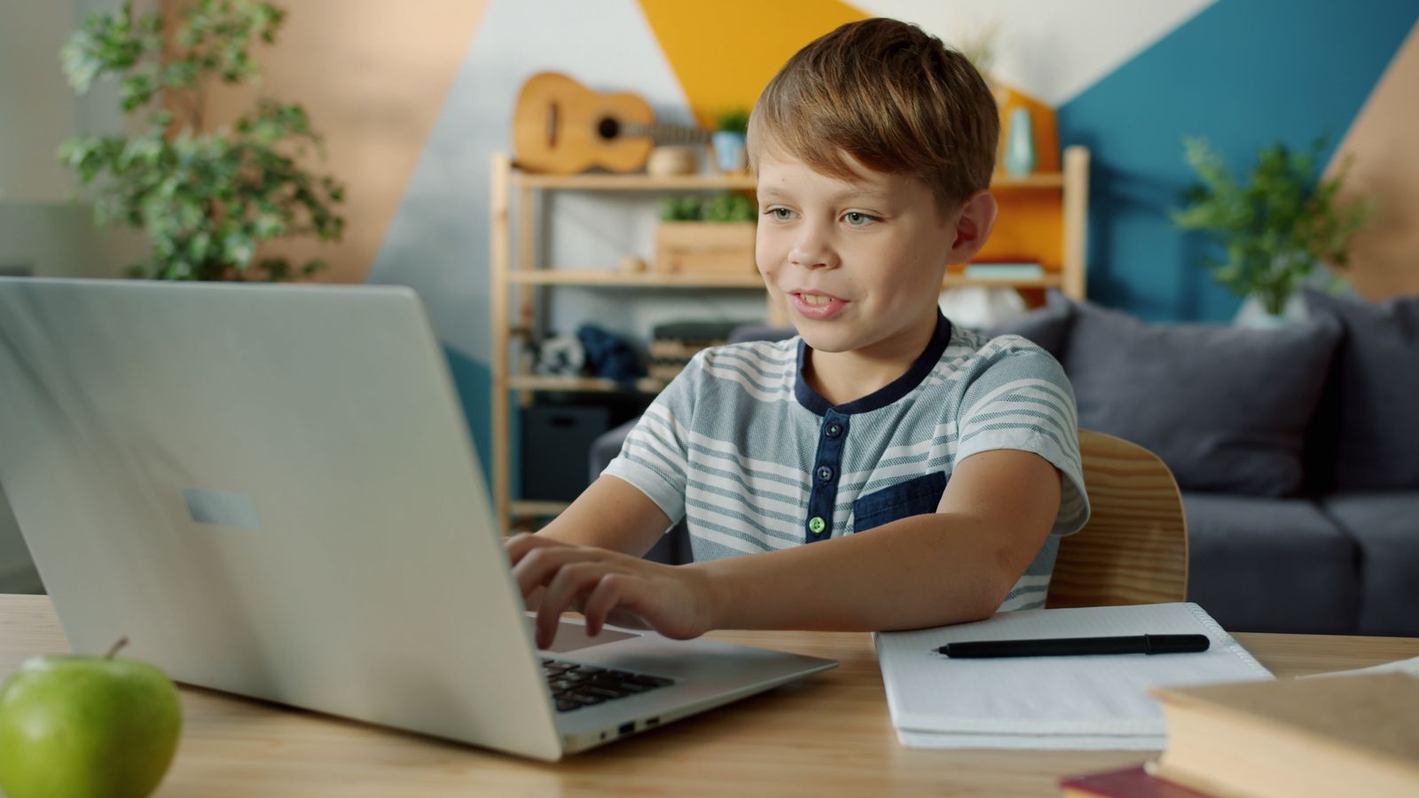 A child engaged in an interactive learning activity on a screen at home