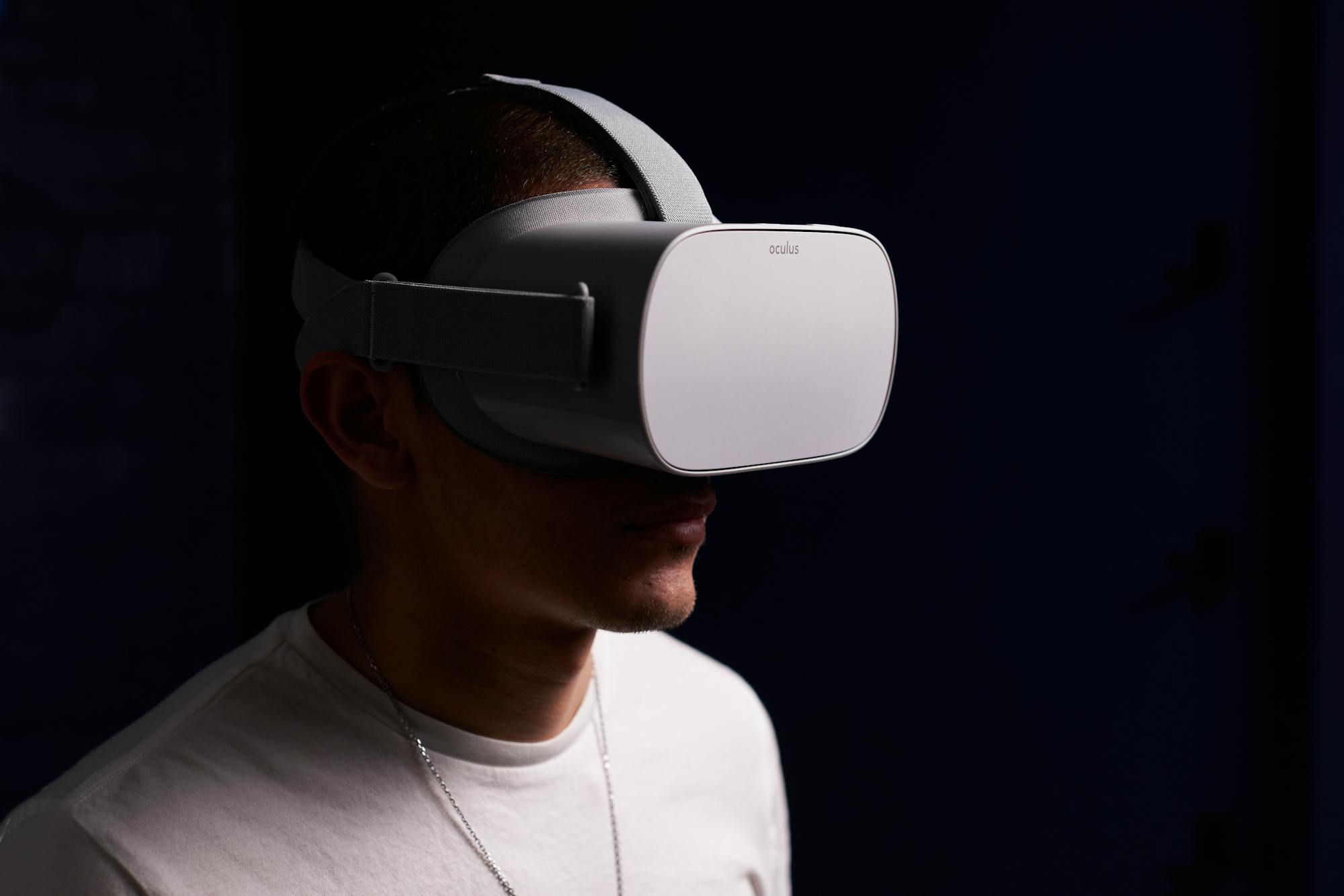 A person wearing a standalone VR headset, lit against a dark background