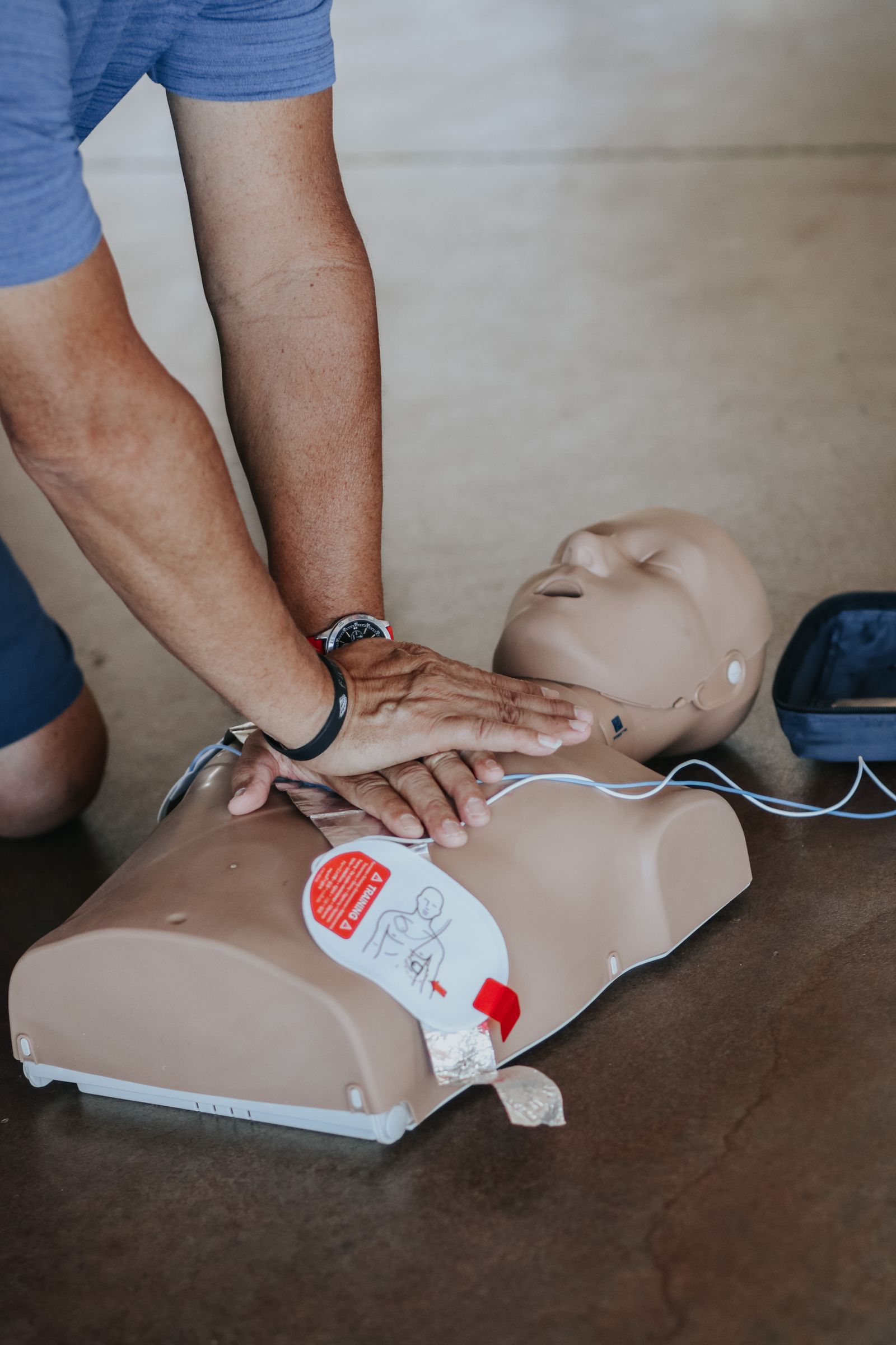 Close-up of hands performing chest compressions on a training dummy