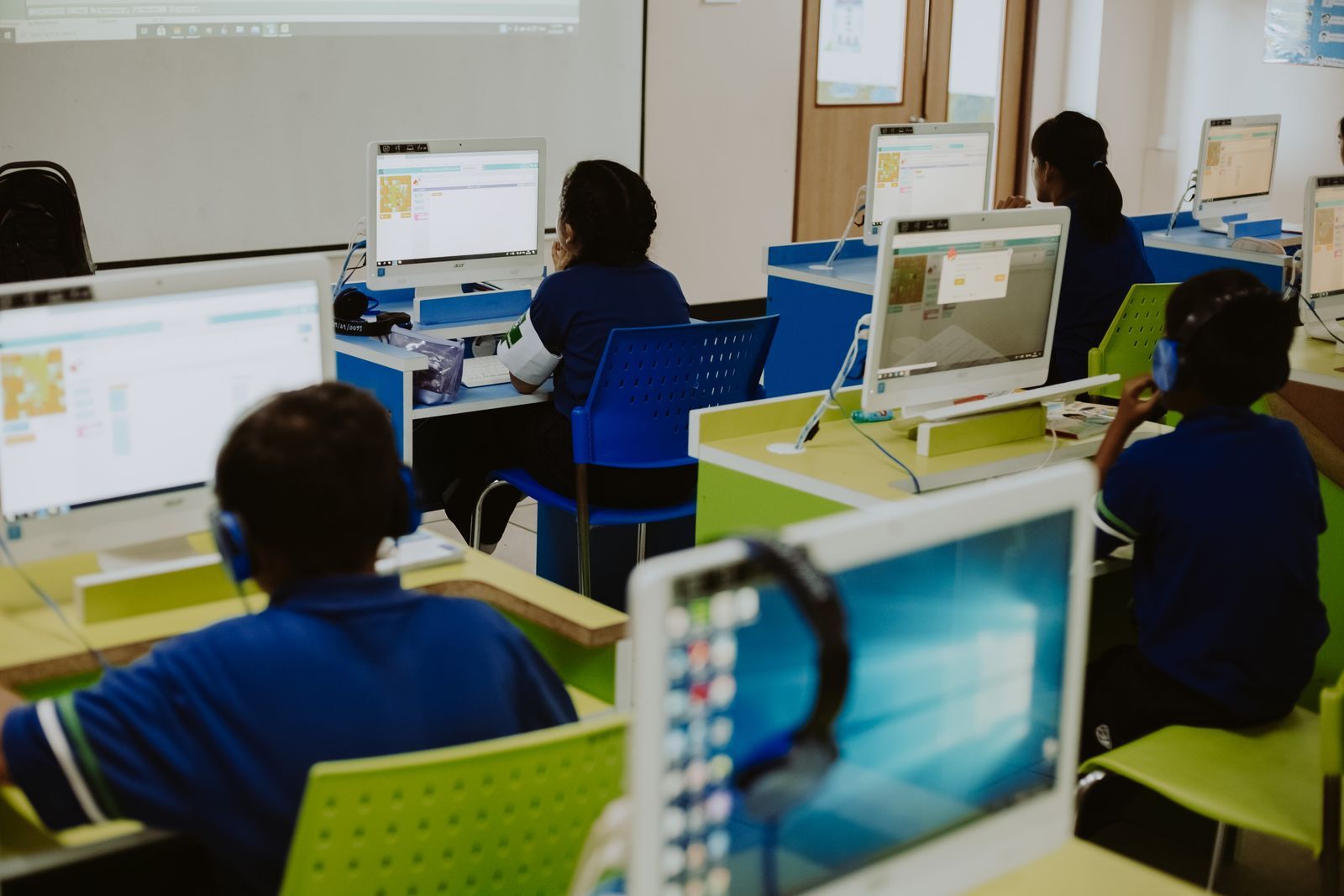 Students working at computers together in a bright classroom