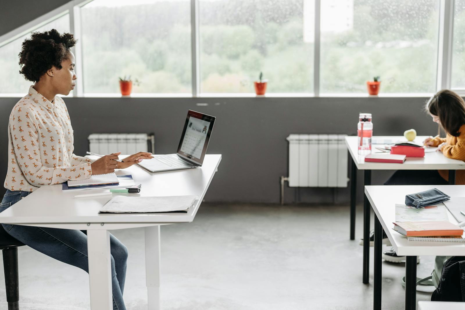 An educator working at a laptop, building course content