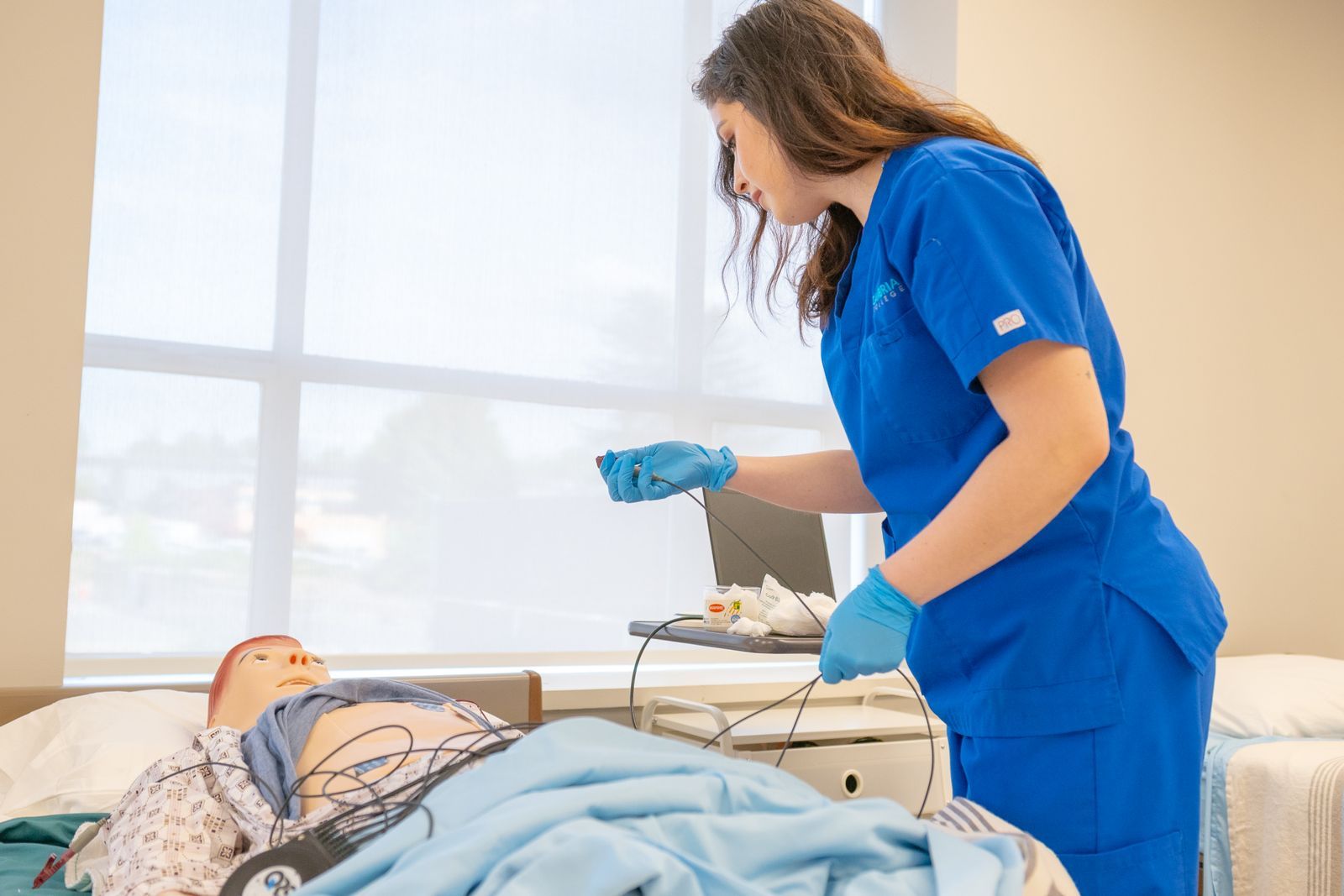 A health-care student practising a clinical procedure on a training manikin