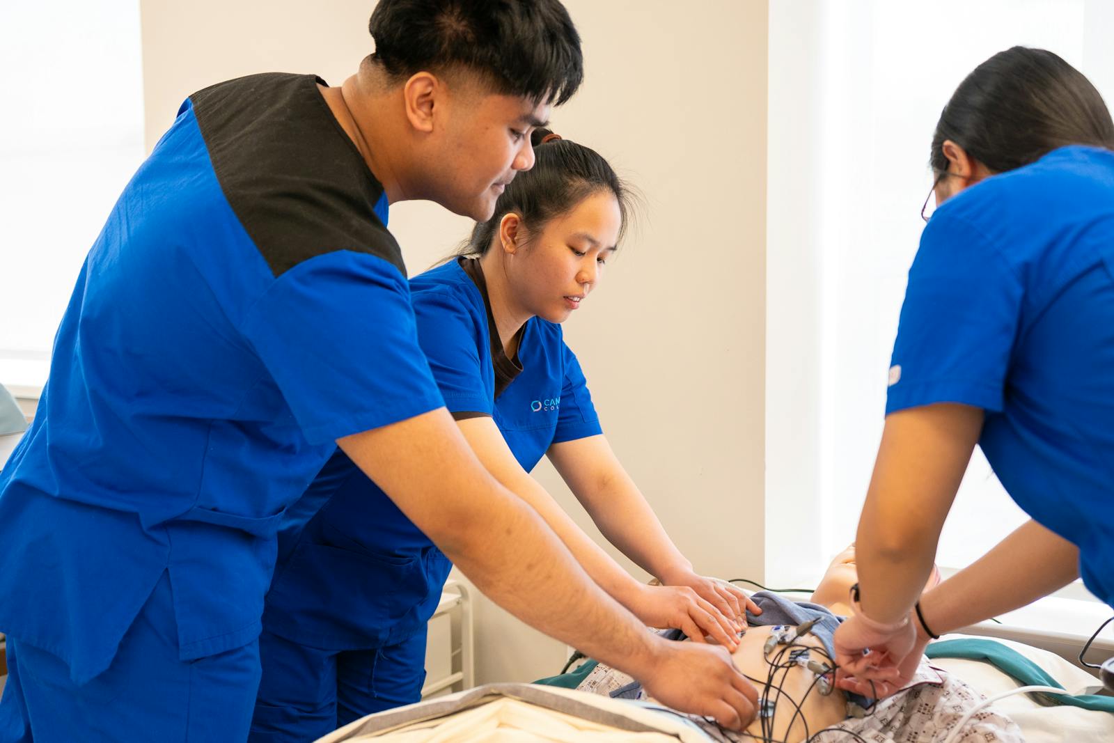 Nursing students practising patient care together in a simulation classroom