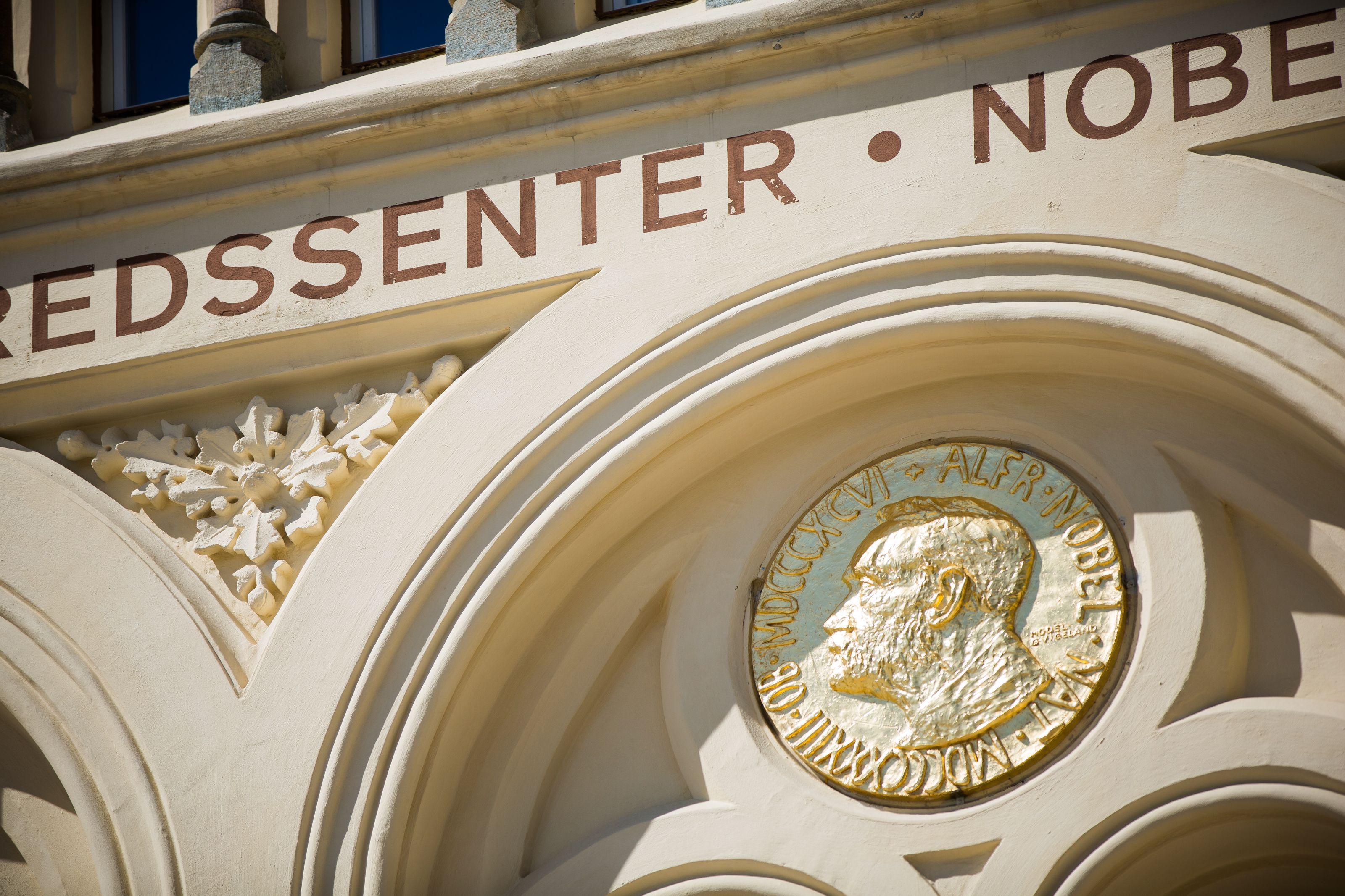 Bilde av fredsprismedaljen på fasaden av Nobels Fredssenter.