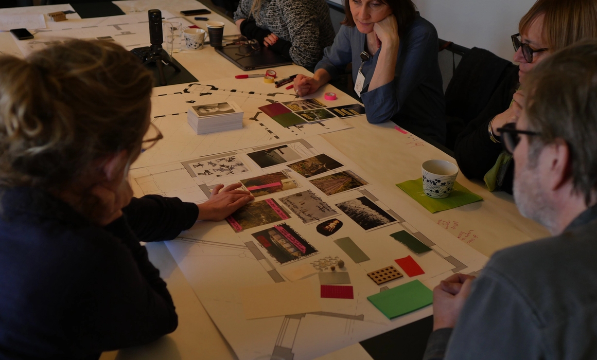 a collage being worked on by people at the table.