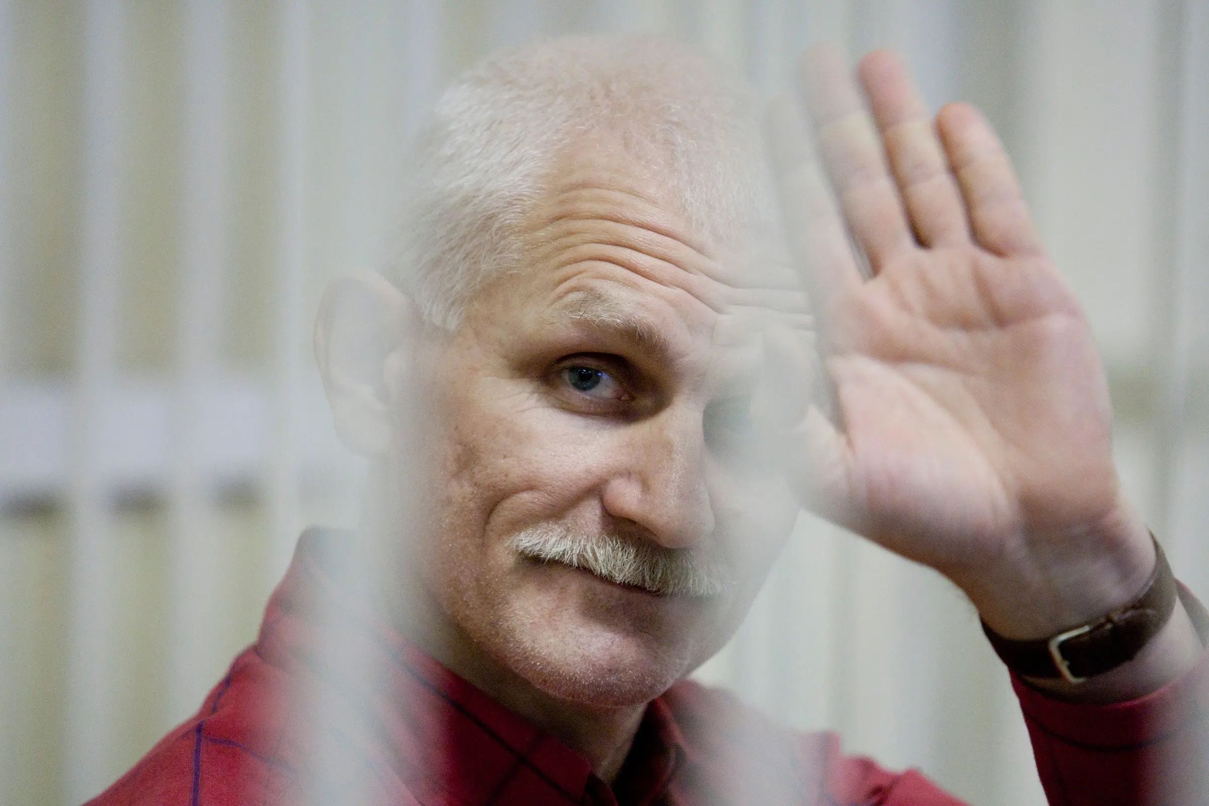 Aljes Bjaljatski waving in jail