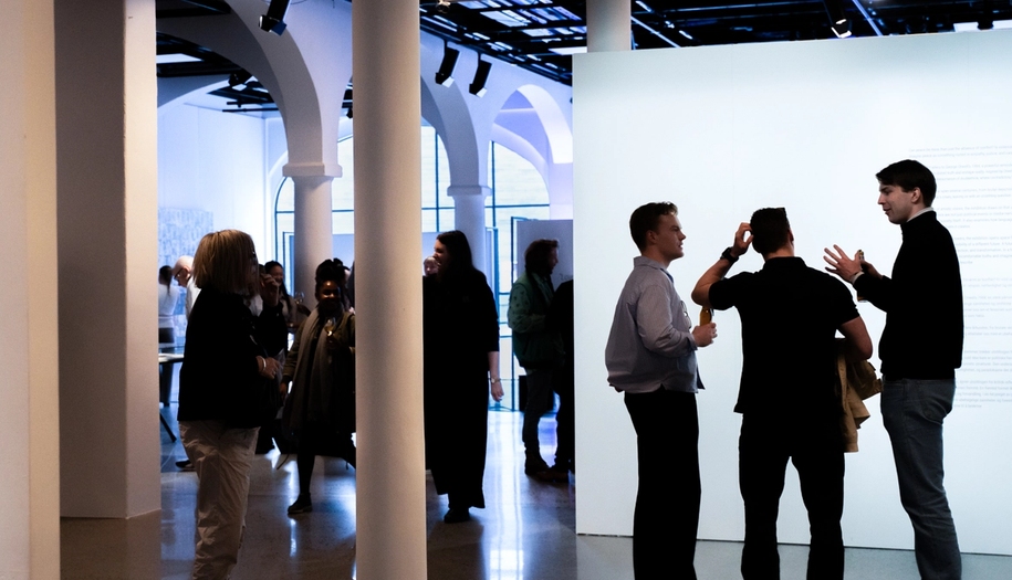 People in an exhibition, socializing.