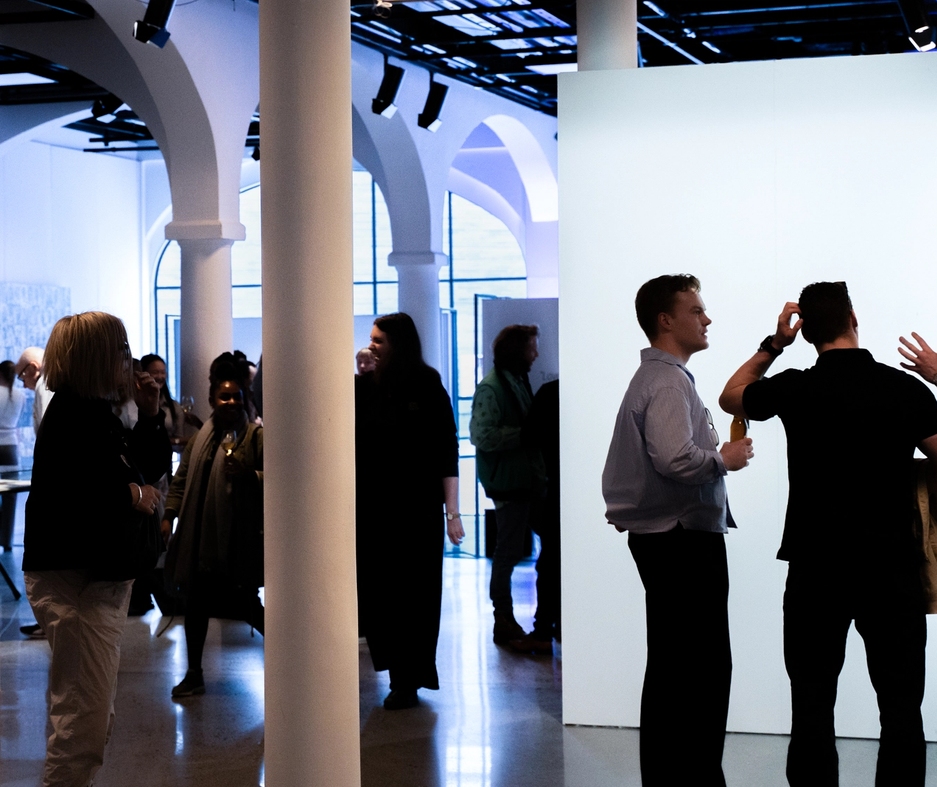 People in an exhibition, socializing.