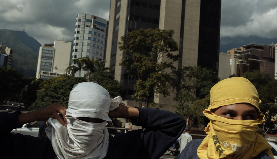 Two men/boys covering their face with tshirts in Venezuela.