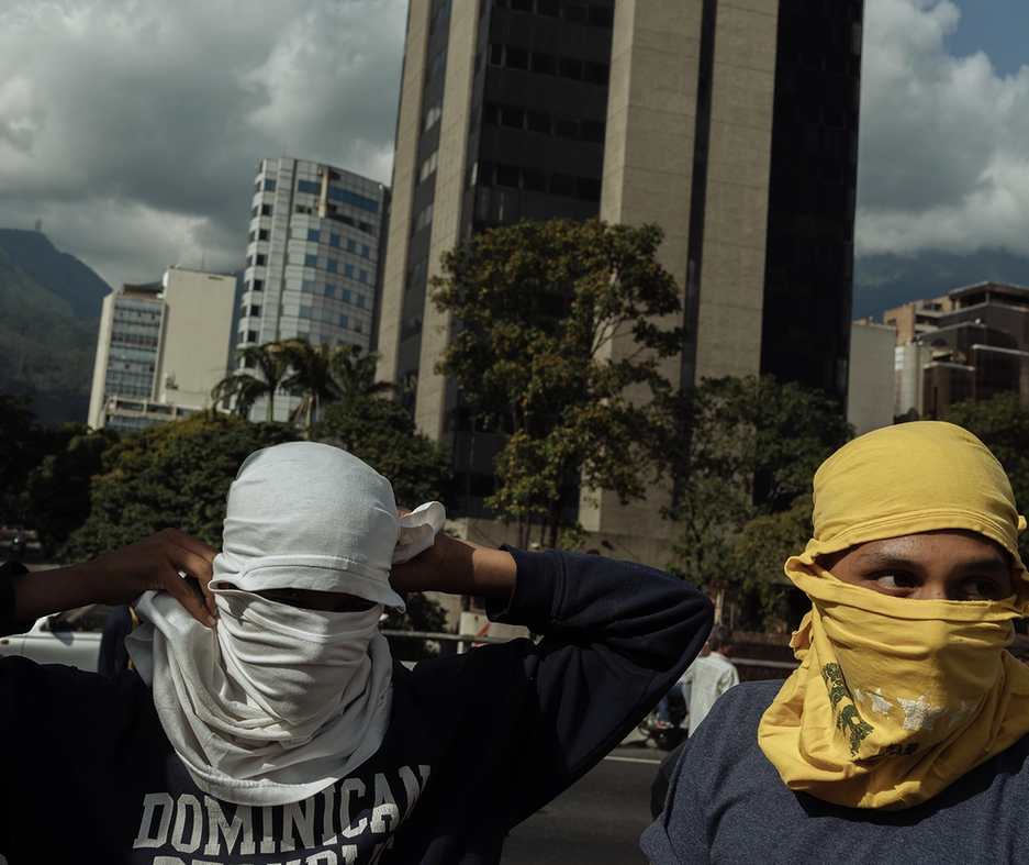 Two men/boys covering their face with tshirts in Venezuela.