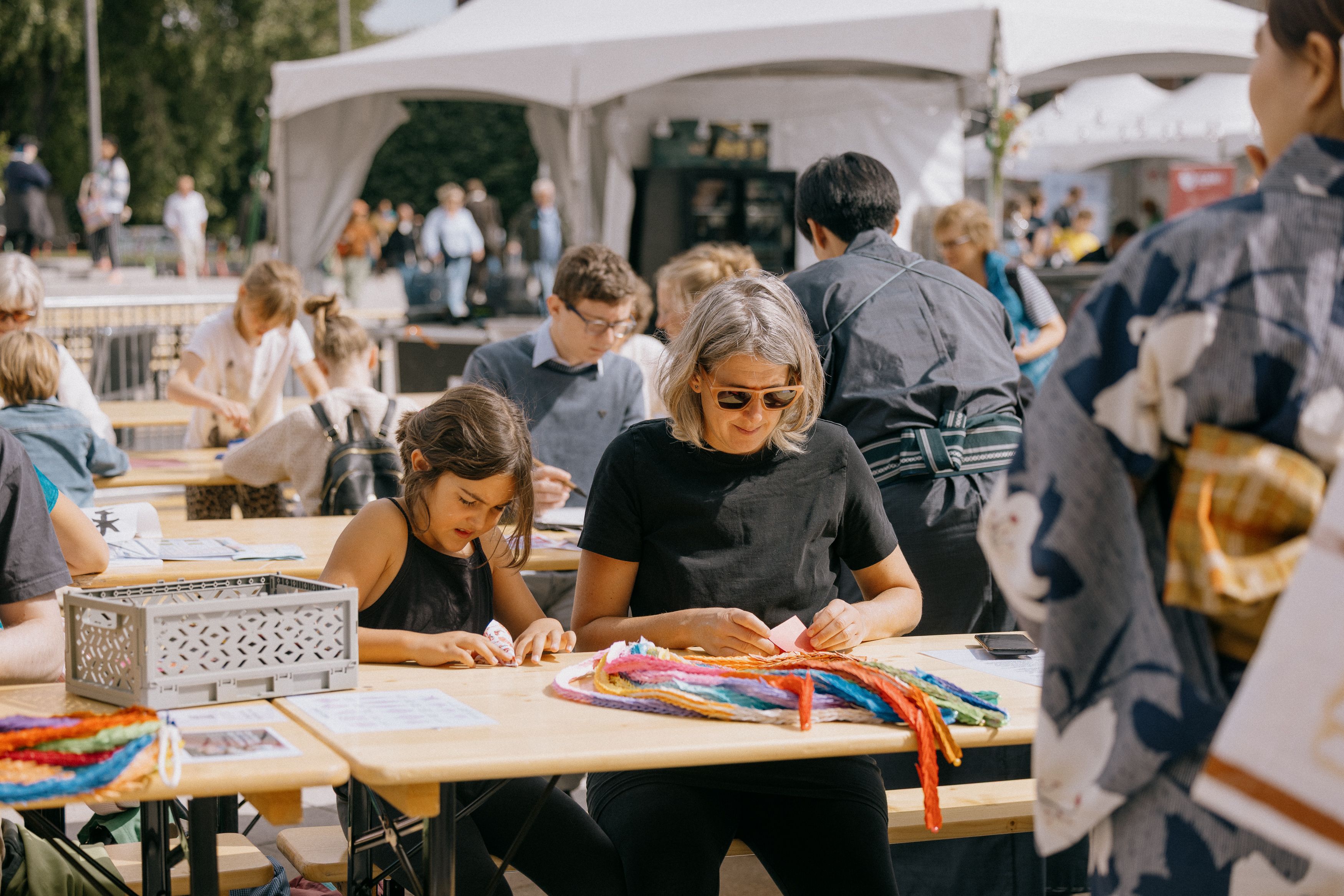 girl and woman folding origami cranes.