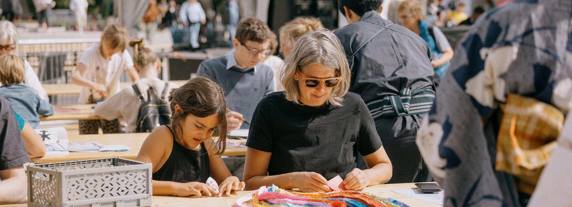 girl and woman folding origami cranes.