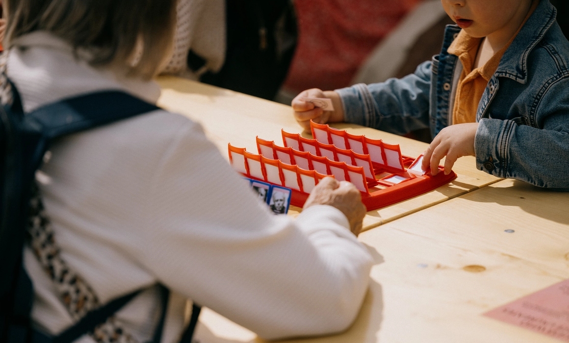 kid playing who's who with his grandmother.