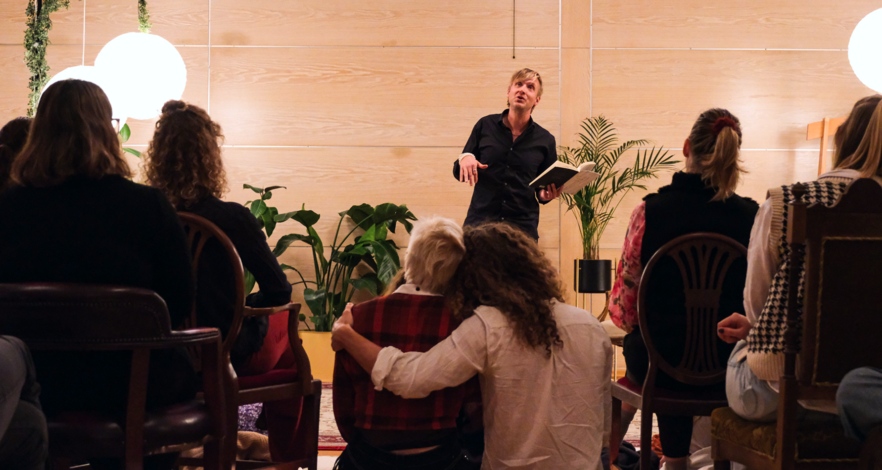 from poetry session, audience watching man performing.