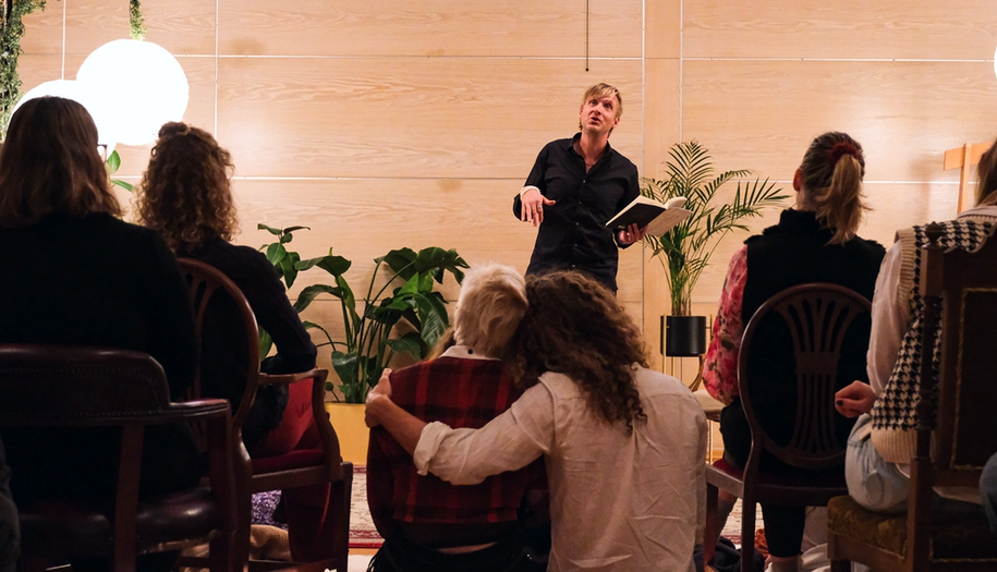 from poetry session, audience watching man performing.