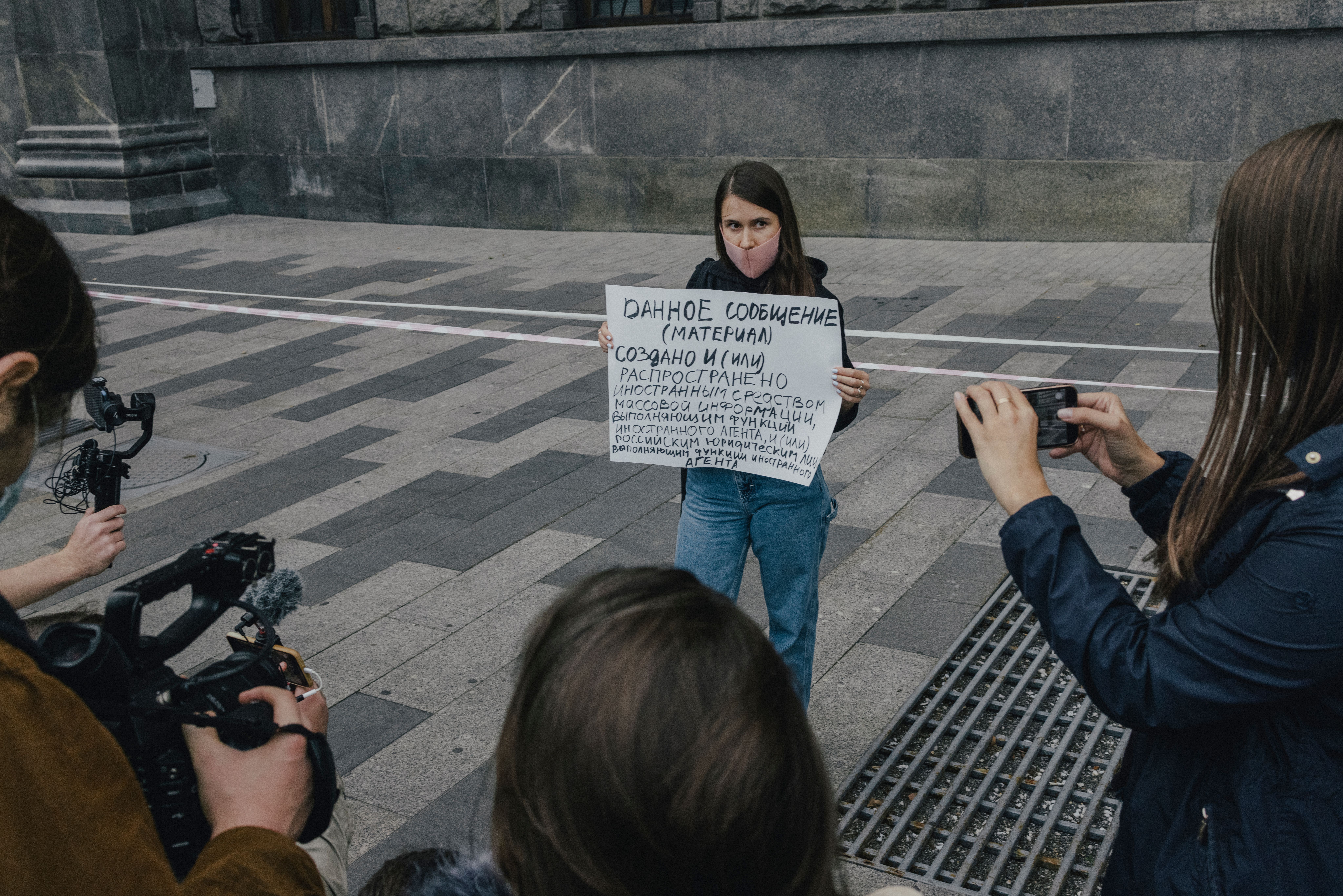 protester with a big poster and mask on face.