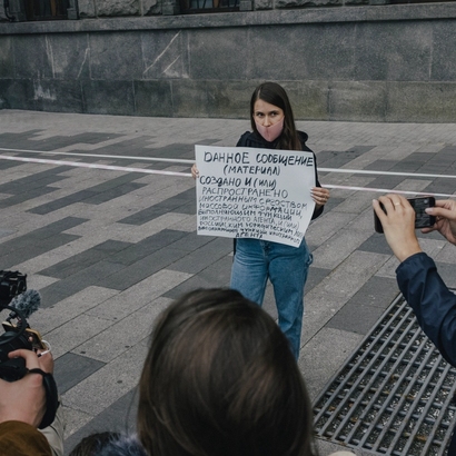 protester with a big poster and mask on face.