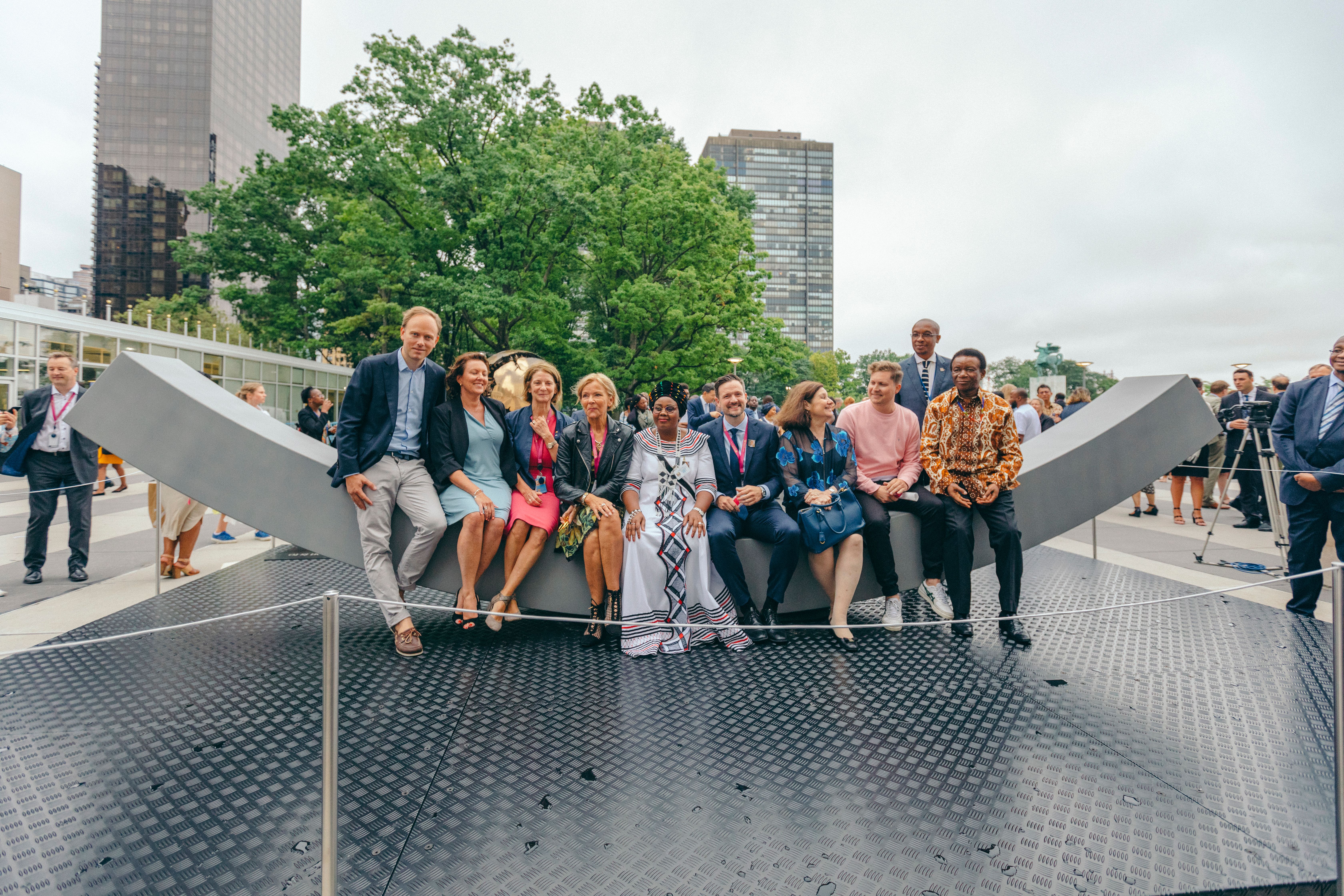The peace bench with a big group of people sitting on the bench.